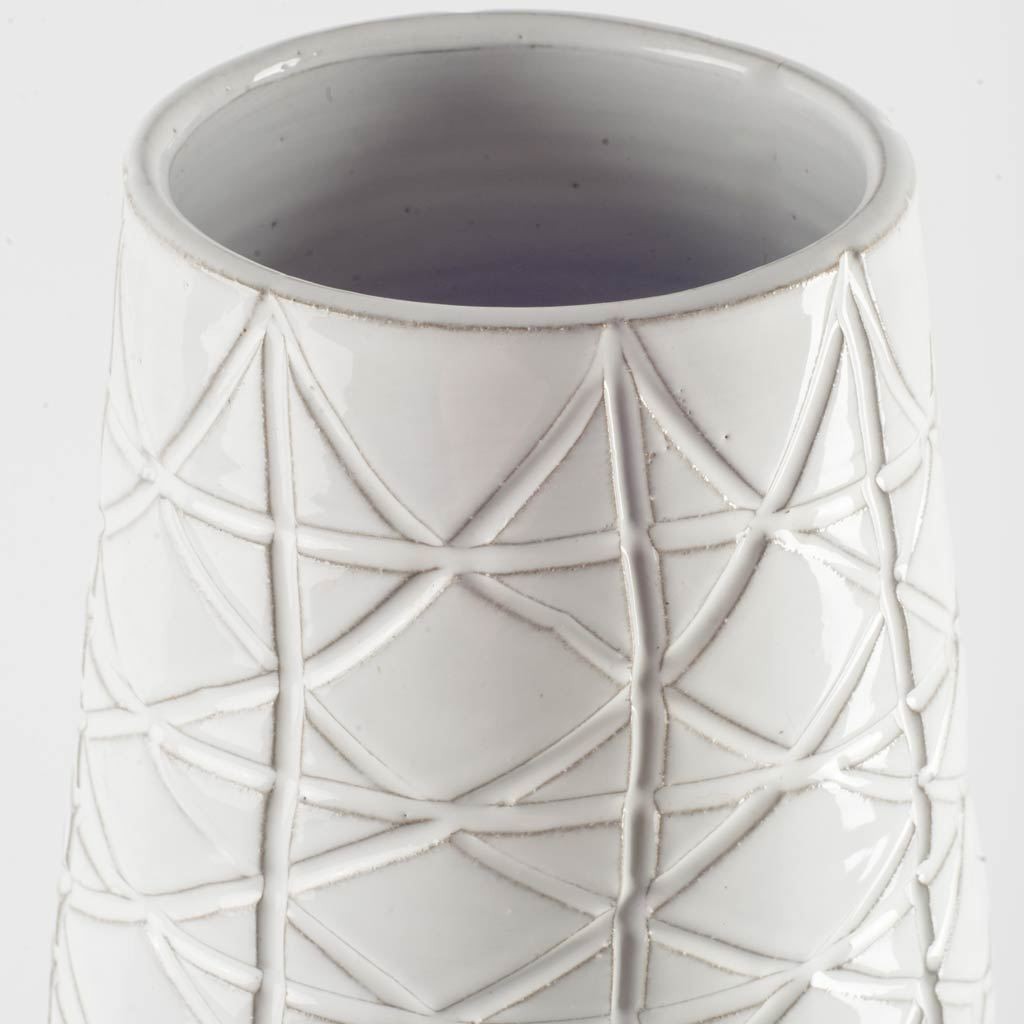 Carved Textured White Ceramic Vase Over Dark Clay