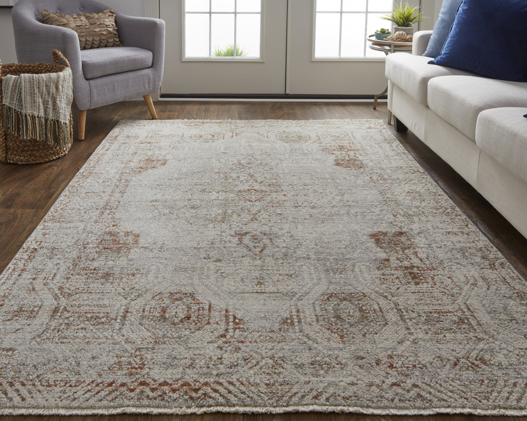10" X 13" Tan Ivory And Orange Floral Power Loom Distressed Area Rug With Fringe
