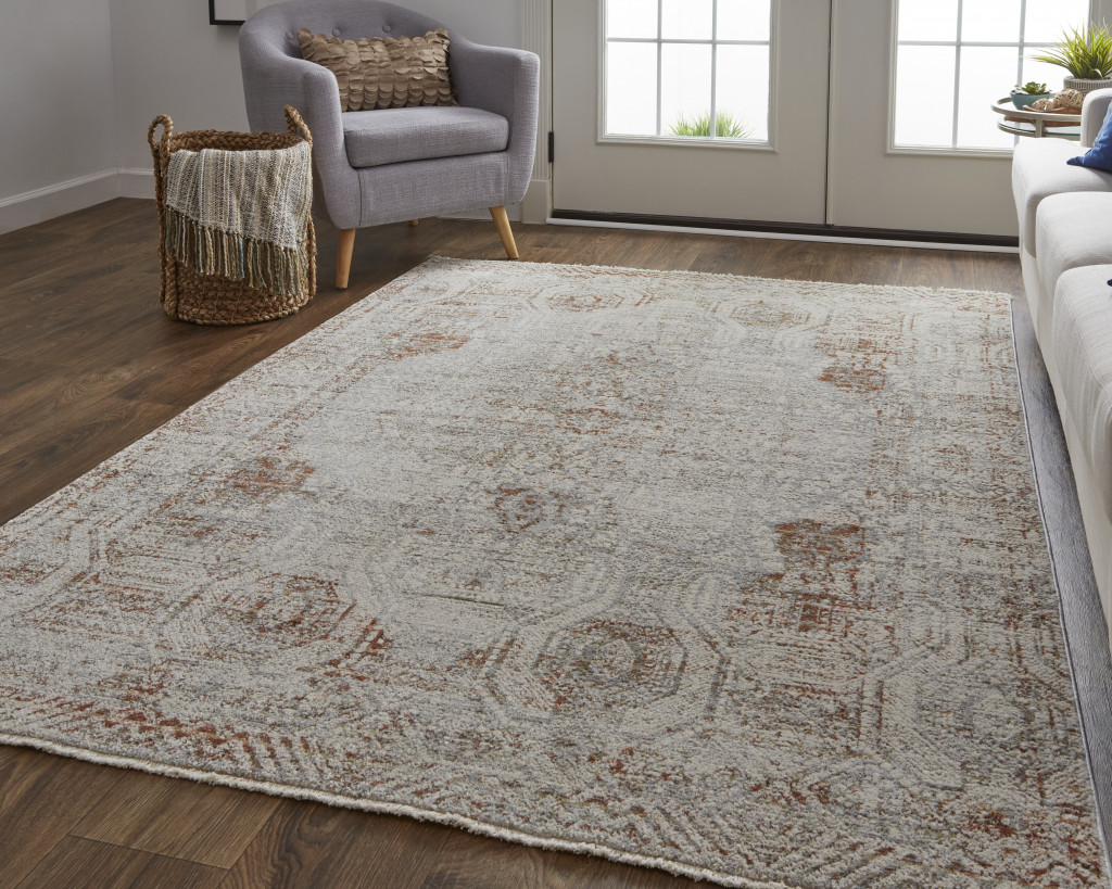 10" X 13" Tan Ivory And Orange Floral Power Loom Distressed Area Rug With Fringe